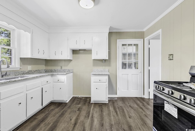 kitchen with dark wood-style flooring, ornamental molding, white cabinets, a sink, and stainless steel gas range