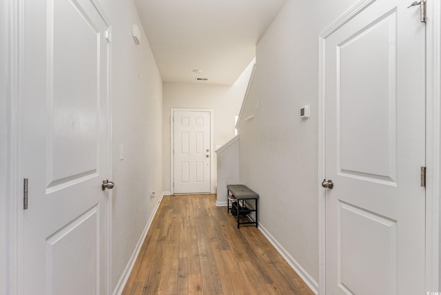 hallway featuring hardwood / wood-style floors and baseboards