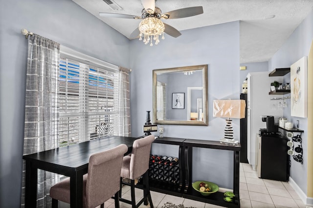 dining space featuring light tile patterned floors, visible vents, ceiling fan, a textured ceiling, and a bar