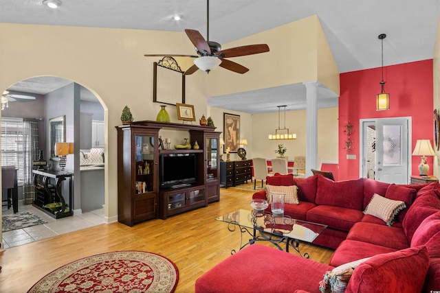 living room with arched walkways, ceiling fan, light wood-style flooring, and decorative columns