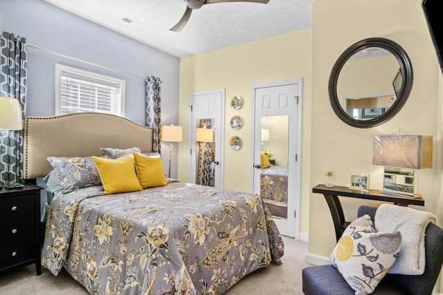 carpeted bedroom with a ceiling fan, visible vents, a textured ceiling, and baseboards