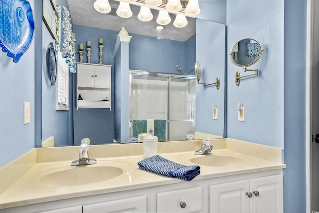 bathroom featuring a sink, a shower stall, and double vanity