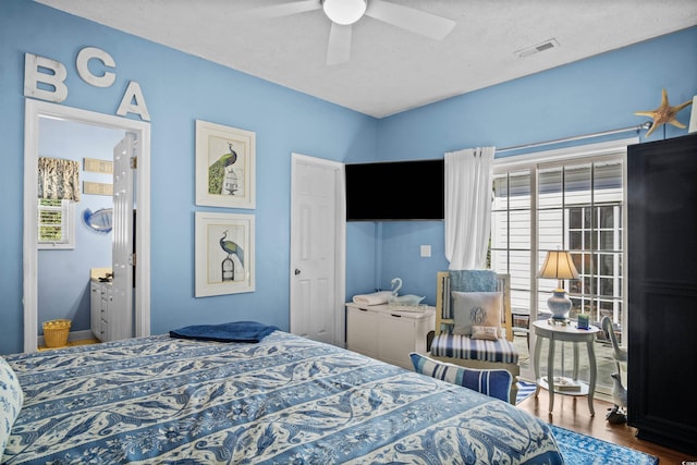 bedroom with ceiling fan, multiple windows, wood finished floors, and visible vents