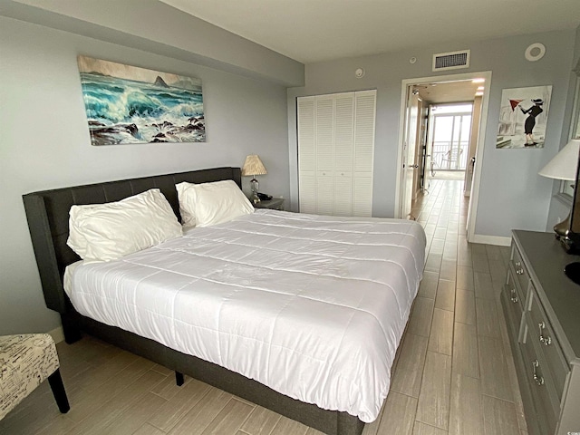 bedroom featuring baseboards, visible vents, and wood finish floors