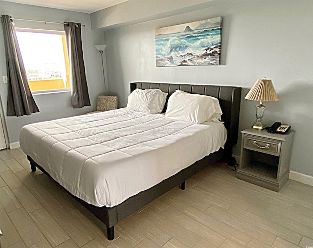 bedroom featuring baseboards and wood finished floors