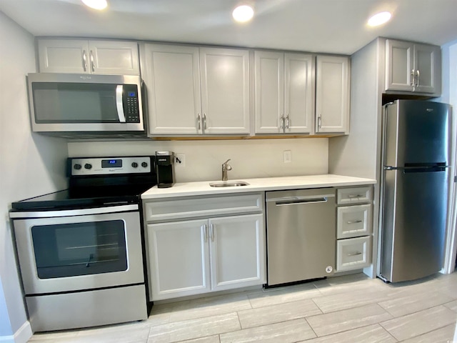 kitchen featuring recessed lighting, stainless steel appliances, a sink, and light countertops