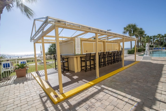 view of patio with an outdoor pool and outdoor dry bar