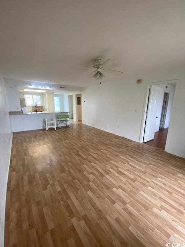 unfurnished living room featuring wood finished floors and a ceiling fan