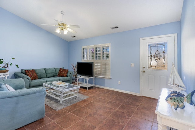 living area featuring baseboards, visible vents, vaulted ceiling, and a ceiling fan