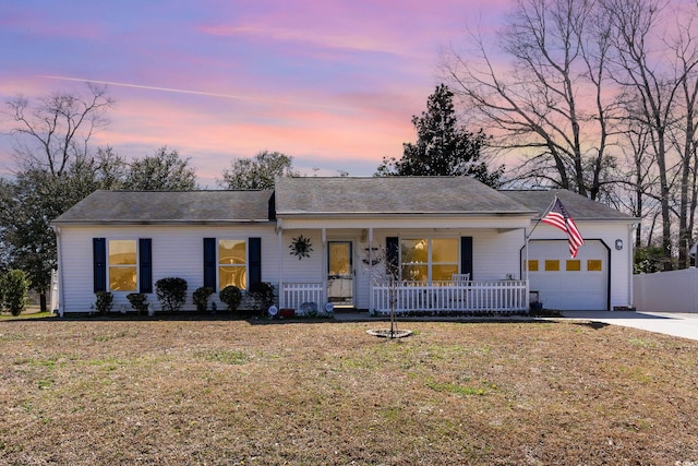 ranch-style home with a garage, covered porch, a yard, and driveway