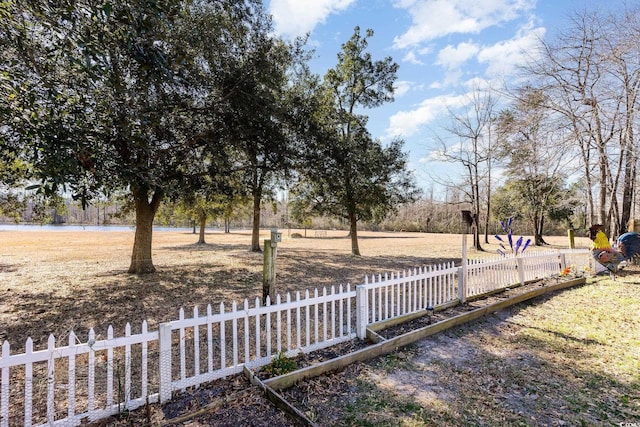 view of yard featuring a water view and fence