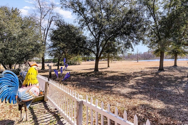 view of yard featuring a water view and fence