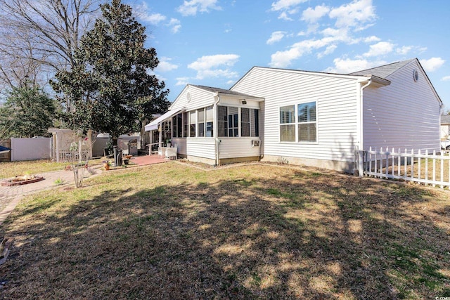 exterior space with a sunroom, a patio area, fence, and a lawn