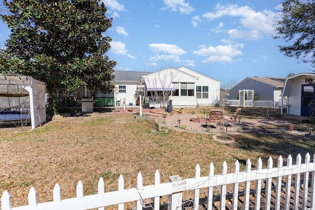 rear view of house featuring fence private yard, a patio area, and a lawn