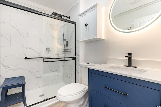 full bathroom featuring toilet, a marble finish shower, and vanity