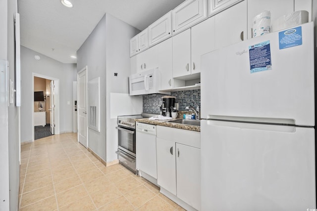 kitchen with light tile patterned floors, white appliances, a sink, white cabinetry, and decorative backsplash