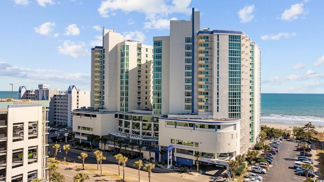 view of building exterior with a beach view and a water view