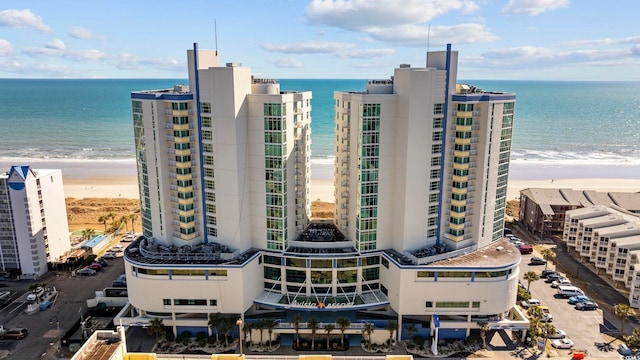 view of building exterior featuring a water view and a view of the beach