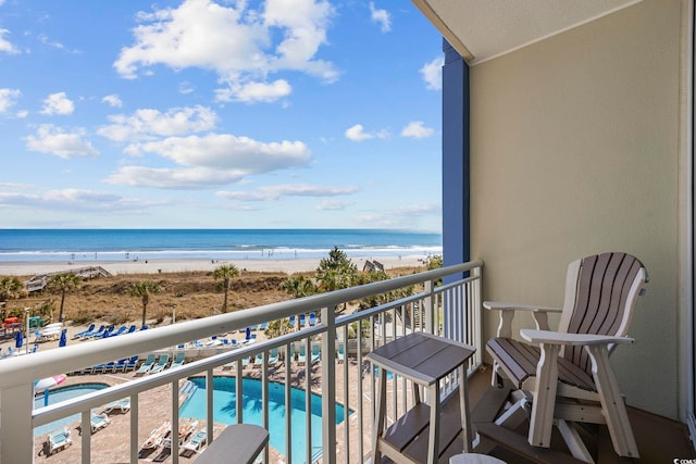 balcony featuring a beach view and a water view