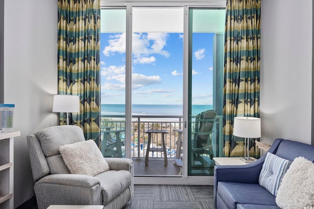 interior space with a view of the beach, floor to ceiling windows, and a water view