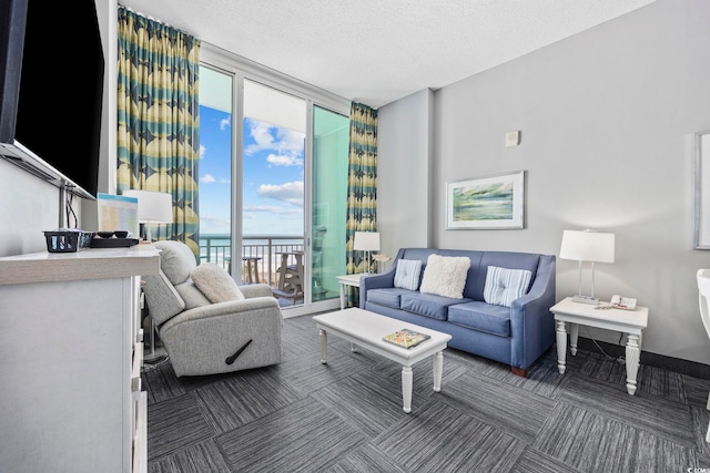 carpeted living area featuring a wall of windows, a textured ceiling, and baseboards