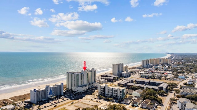 drone / aerial view featuring a water view, a view of the beach, and a city view