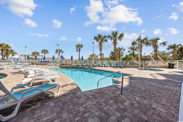 community pool featuring a patio area and fence