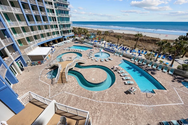 birds eye view of property with a water view and a beach view