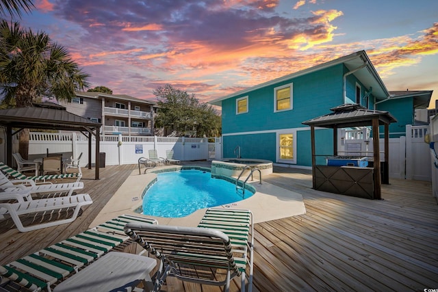 view of pool with a fenced in pool, a fenced backyard, an in ground hot tub, a gazebo, and a wooden deck