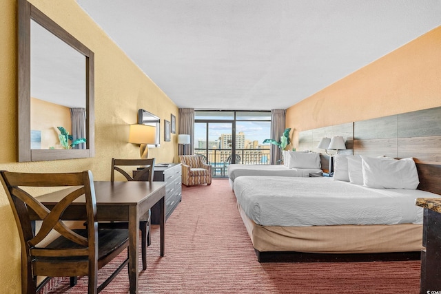 1501 S Ocean Blvd Unit 1005, Myrtle Beach, SC 29577 - bedroom featuring access to exterior, a textured wall, carpet flooring, and a wall of windows