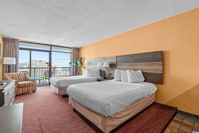 1501 S Ocean Blvd Unit 1005, Myrtle Beach, SC 29577 - bedroom featuring baseboards, a wall of windows, a textured wall, a textured ceiling, and access to outside
