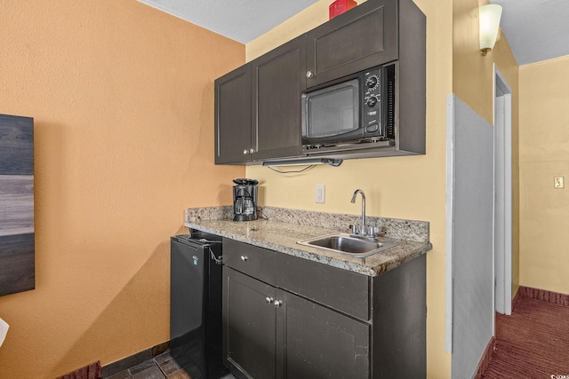 1501 S Ocean Blvd Unit 1005, Myrtle Beach, SC 29577 - kitchen featuring a sink, baseboards, and black microwave