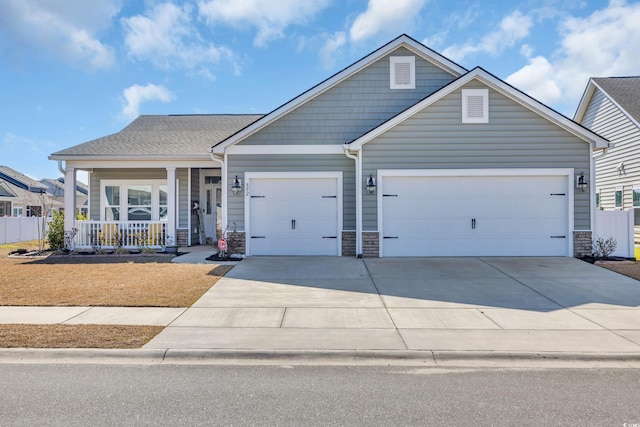 view of front of home with a porch, driveway, a shingled roof, and an attached garage