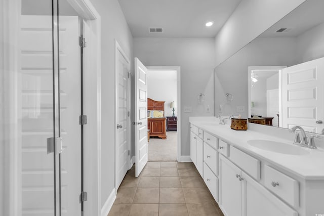 bathroom with tile patterned flooring, visible vents, a sink, and ensuite bathroom