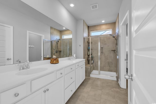 full bathroom featuring double vanity, visible vents, a sink, a shower stall, and tile patterned floors