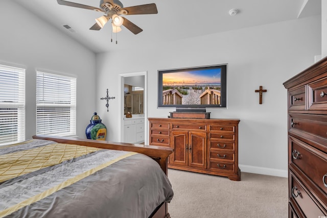 bedroom with light colored carpet, visible vents, connected bathroom, vaulted ceiling, and baseboards