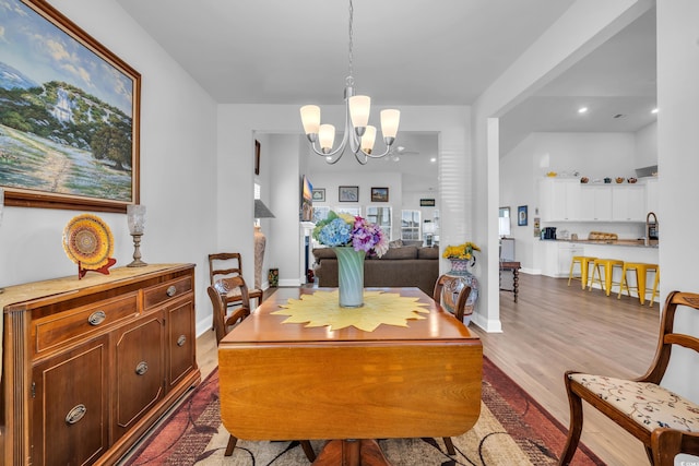 dining area featuring a chandelier, baseboards, and dark wood-style floors