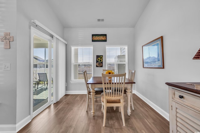 dining room with baseboards, visible vents, and dark wood-style flooring