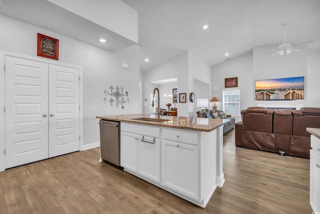 kitchen with light wood-style flooring, a sink, open floor plan, light stone countertops, and dishwasher