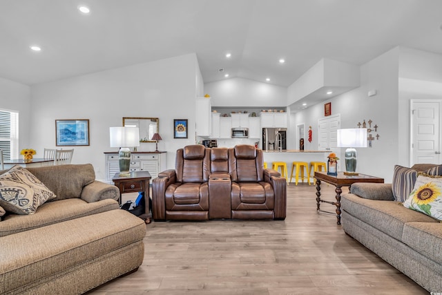 living area with lofted ceiling, light wood finished floors, and recessed lighting