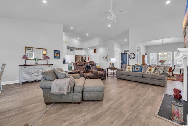 living room featuring light wood-style floors, recessed lighting, high vaulted ceiling, and ceiling fan with notable chandelier