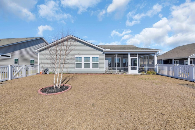 back of house featuring a sunroom, a fenced backyard, a gate, and a lawn