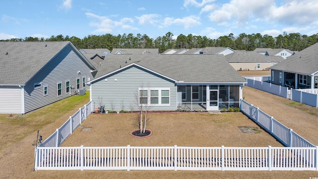 back of house with a sunroom, a fenced backyard, a lawn, and roof with shingles