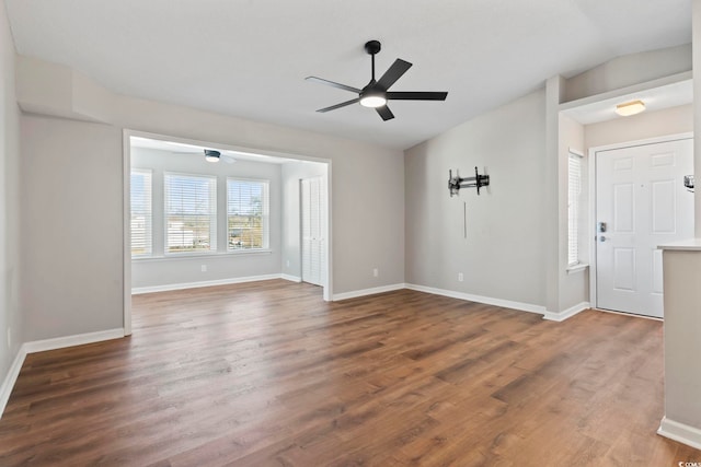 empty room featuring vaulted ceiling, ceiling fan, baseboards, and wood finished floors