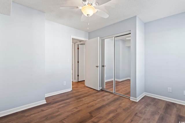 unfurnished bedroom featuring a textured ceiling, a closet, wood finished floors, and baseboards