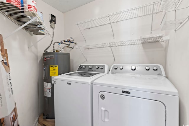 laundry area featuring laundry area, water heater, and separate washer and dryer