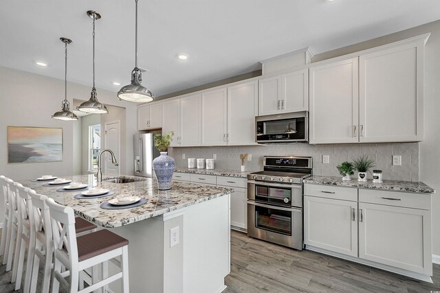 179 Glengrove Ln, Murrells Inlet, SC 29576 - kitchen featuring white cabinetry, decorative backsplash, a sink, and stainless steel appliances