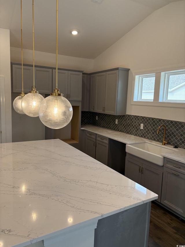 179 Glengrove Ln, Murrells Inlet, SC 29576 - kitchen with gray cabinets, lofted ceiling, light stone counters, decorative backsplash, and dark wood-style flooring