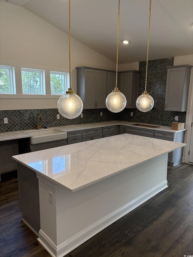 179 Glengrove Ln, Murrells Inlet, SC 29576 - kitchen featuring gray cabinetry, lofted ceiling, backsplash, light stone counters, and dark wood-style floors