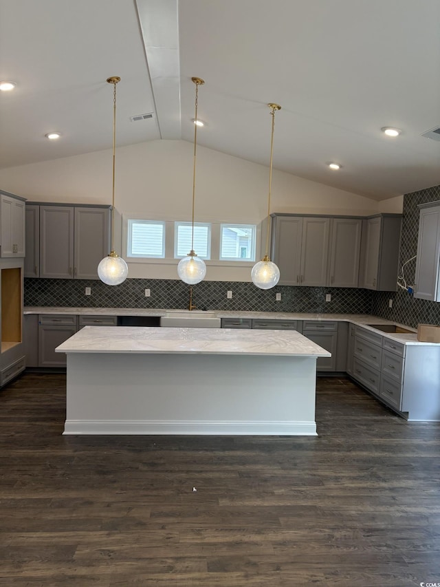179 Glengrove Ln, Murrells Inlet, SC 29576 - kitchen with gray cabinets, lofted ceiling, decorative backsplash, hanging light fixtures, and a kitchen island
